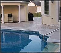 Spray-Deck Texture around pool. Stamped Concrete on outside perimeter in Olde <br />English Slate pattern